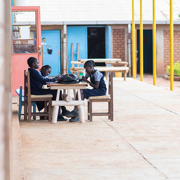 Girls in school uniforms sit at a table to study for exams.
