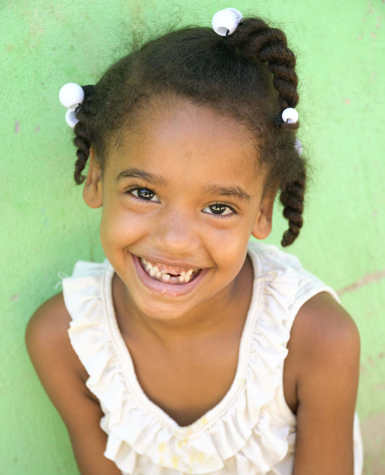 A girl smiles at the camera. © Fundación La Merced / Dominican Republic