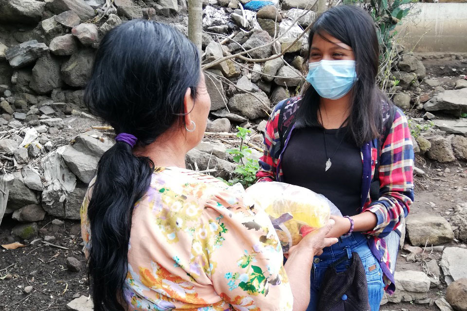 A Coincidir volunteer delivers a food package to a community member.