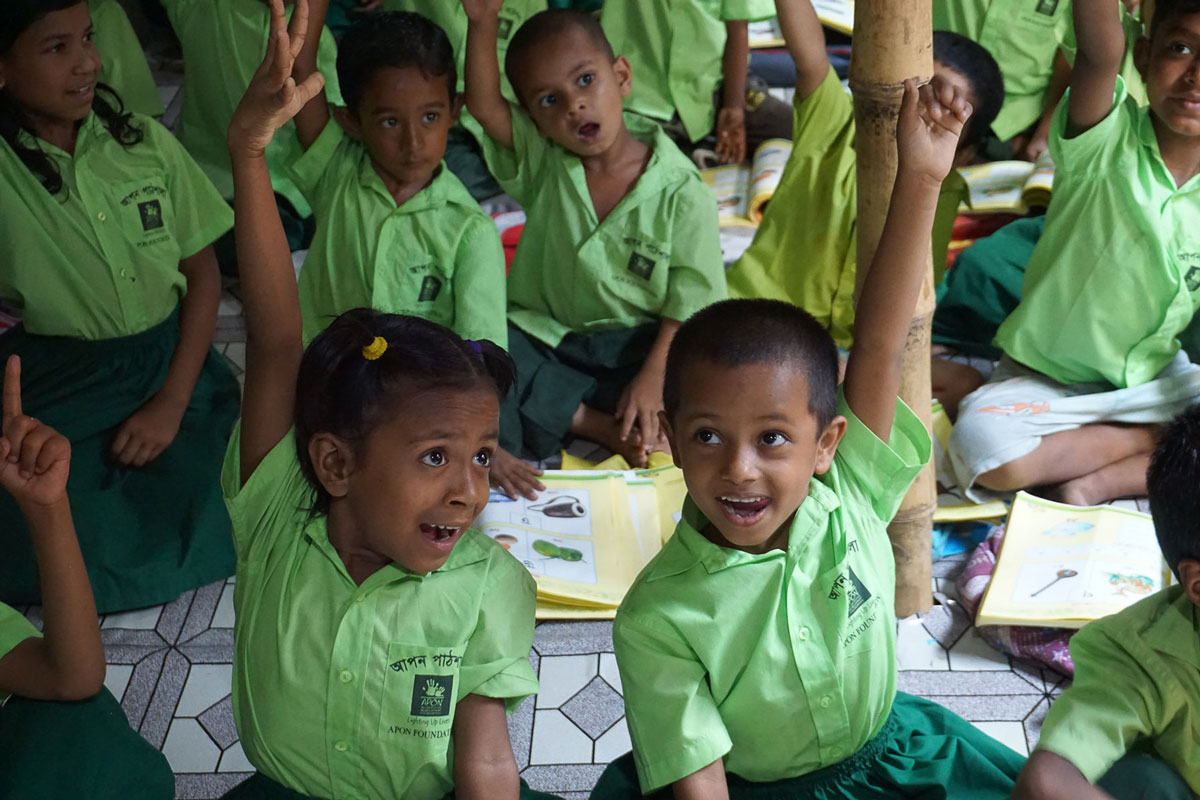 Children raise their hands during an APON Foundation program.