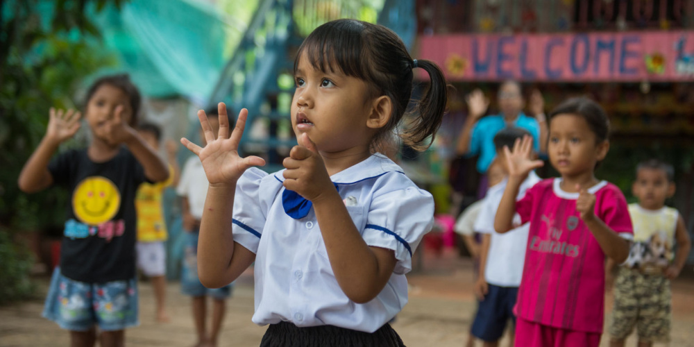 A girl looks up while exercising outside. Photo credit: Kimlong Meng.