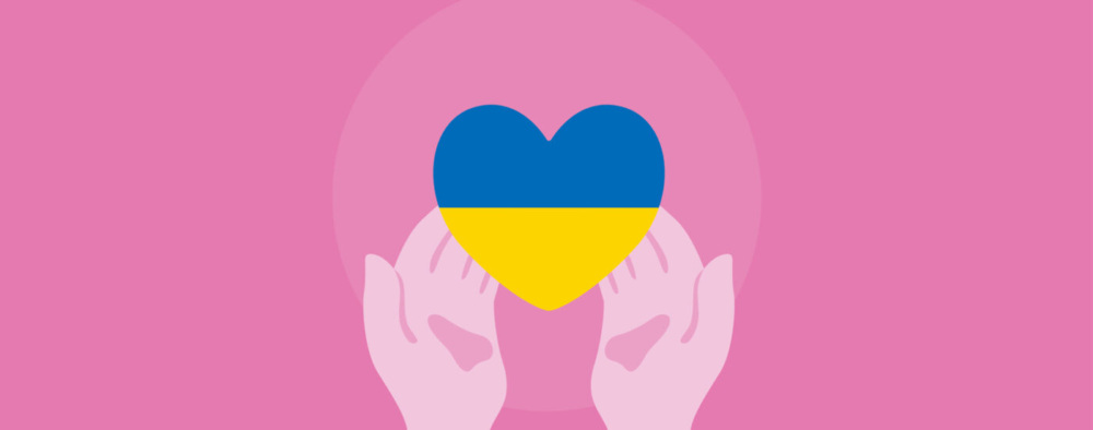 Pink hands holding a heart with the colors of the Ukrainian flag