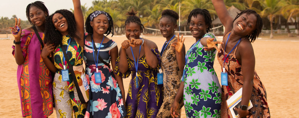 A group of adolescents smiling on a beach