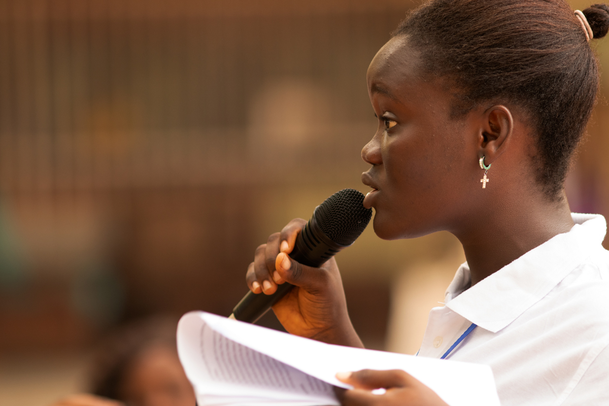 A young woman speaking into a microphone
