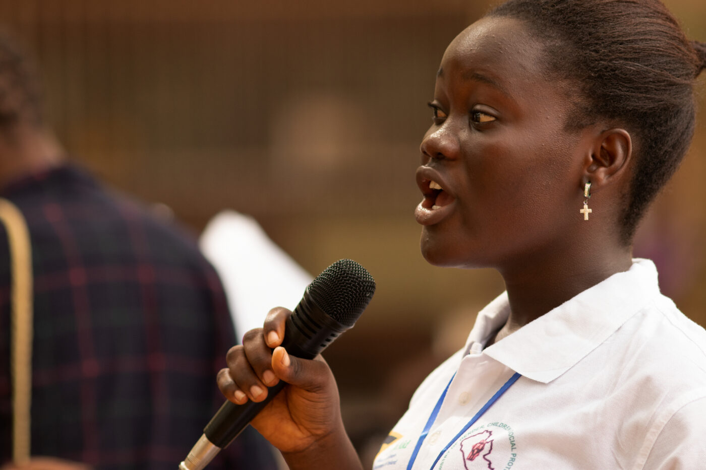 Girl speaking into microphone at the West Africa Adolescent Girls Summit, 2022. 