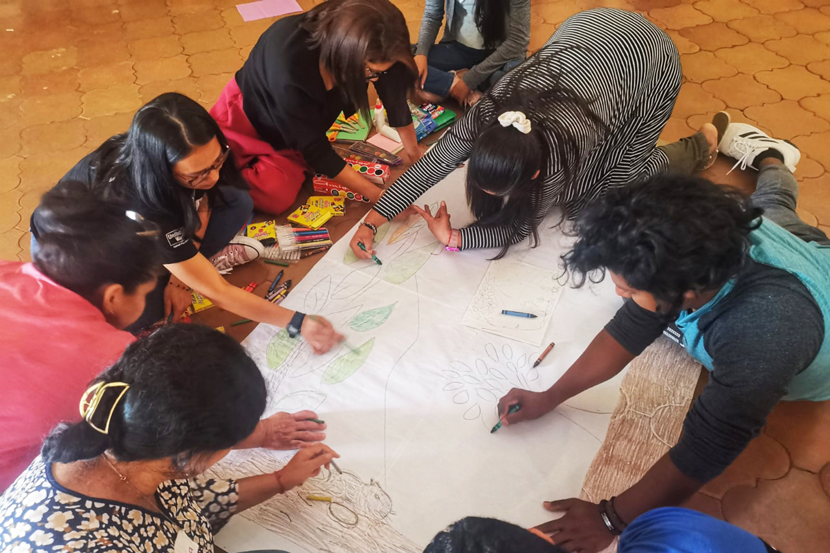 A group of participants at the SEED convening engaged in a drawing activity on the floor
