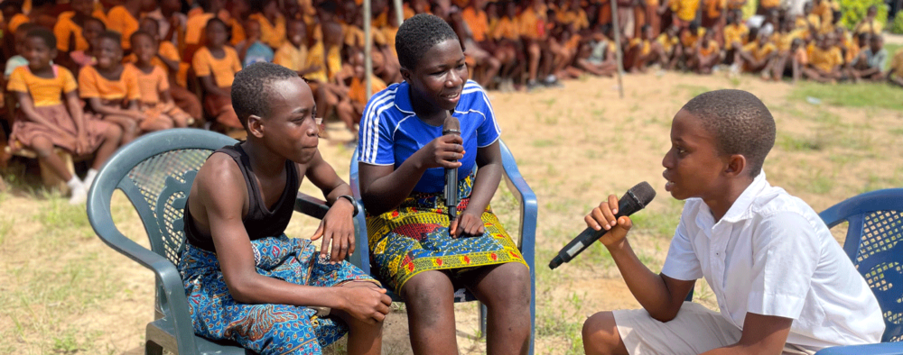 Three children holding microphones