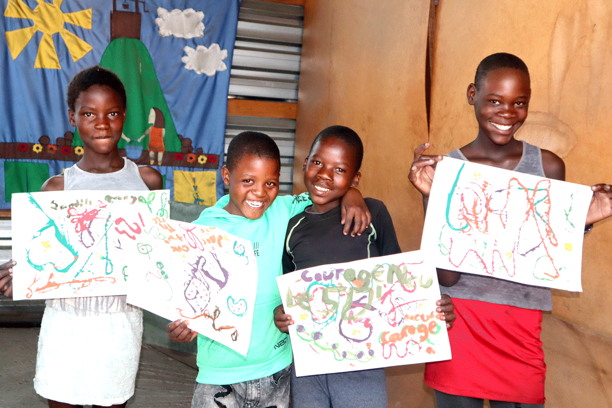 Children showing off their work after an art class 