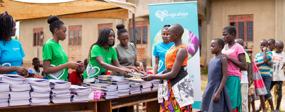 Books and stationery being handed over to a girl at a Back-to-School drive