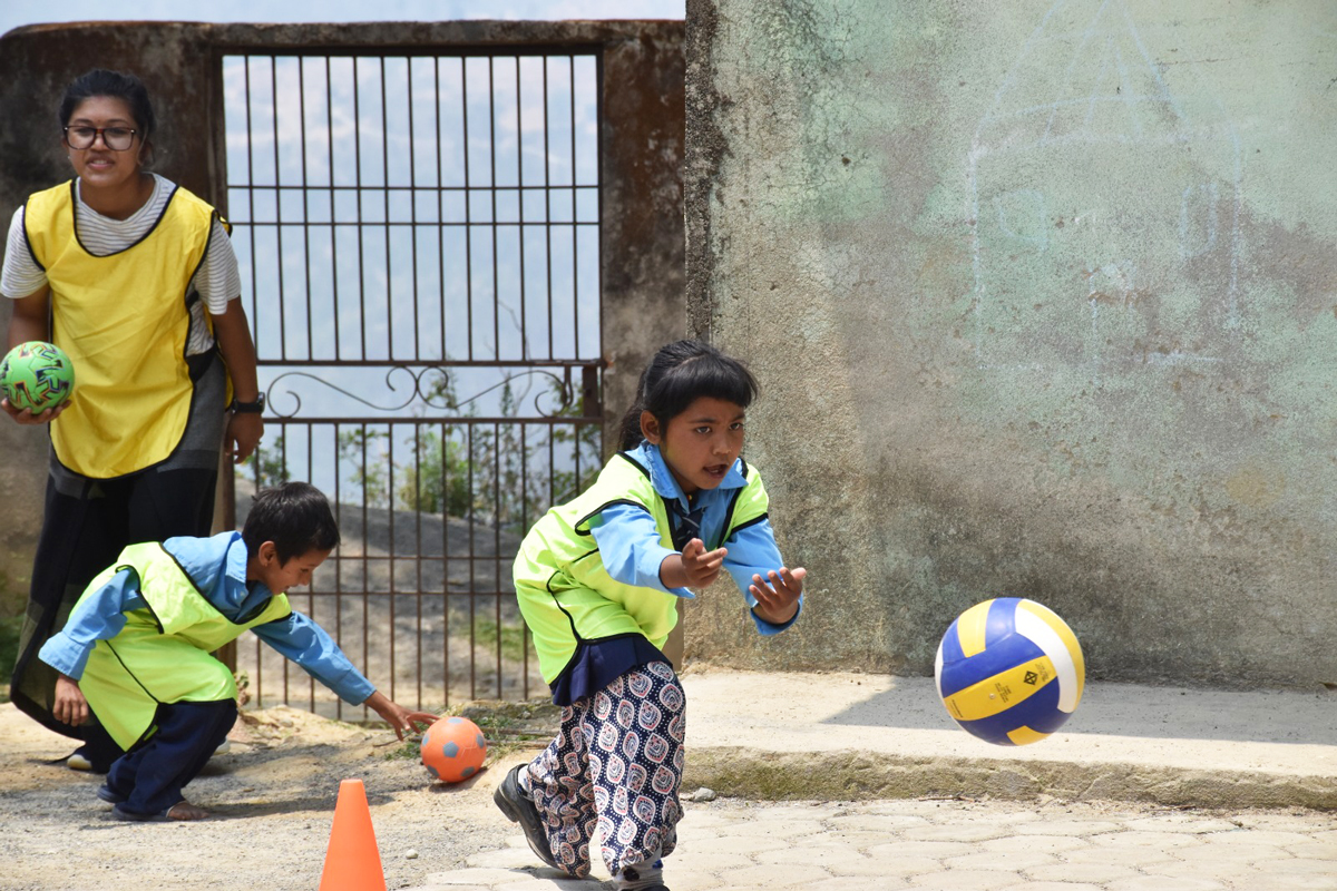 Children playing outdoors with a ball. 