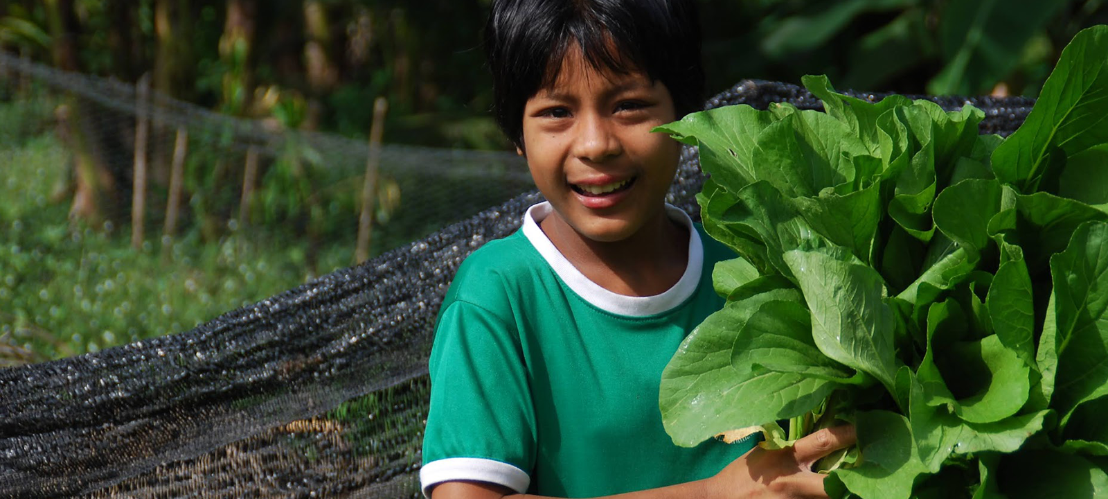 Young person holding crops from community-garden.