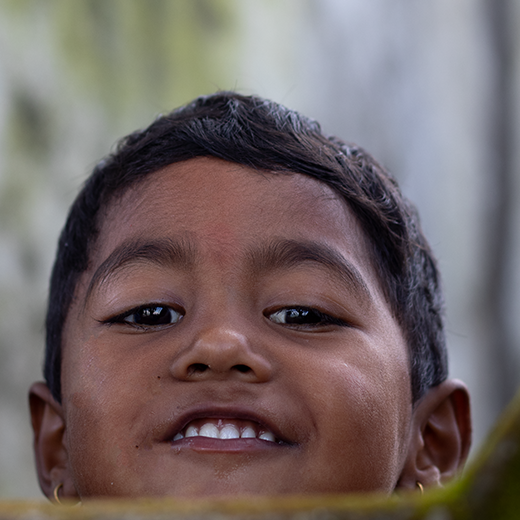 Young boy poking head. behind classroom wall.