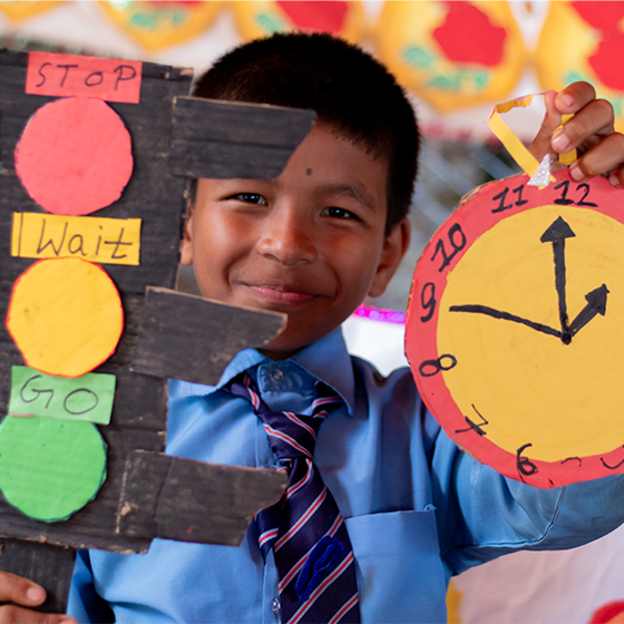 Young student holding 'signs' used in learning.