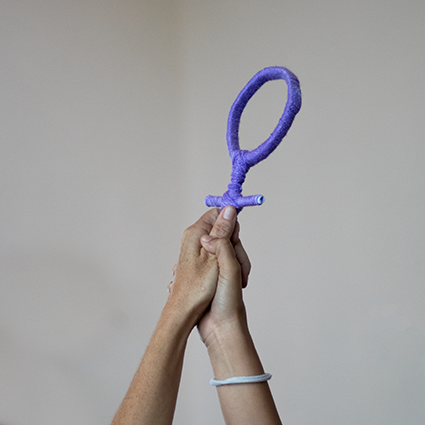 Two hands holding the symbol of feminism.