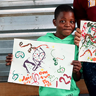 Boy holding his artwork.